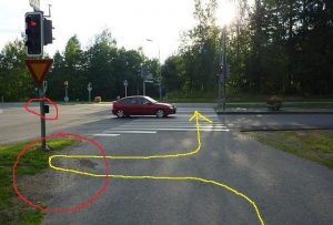 Liikennevalot Keskussairaalantien ja Savelankadun risteyksessä. Liikennesääntöjen mukainen ajoreitti on merkitty keltaisella, risteyksen ongelmat punaisella.